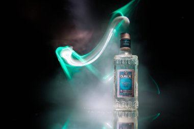 Bakü, Azerbaycan - 16 Haziran. 2019. Koyu tonda sisli arka plan üzerinde ahşap masa üzerinde Olmeca Tekila. Olmeca Tekila Jalisco, Meksika'da üretilen bir tekila.