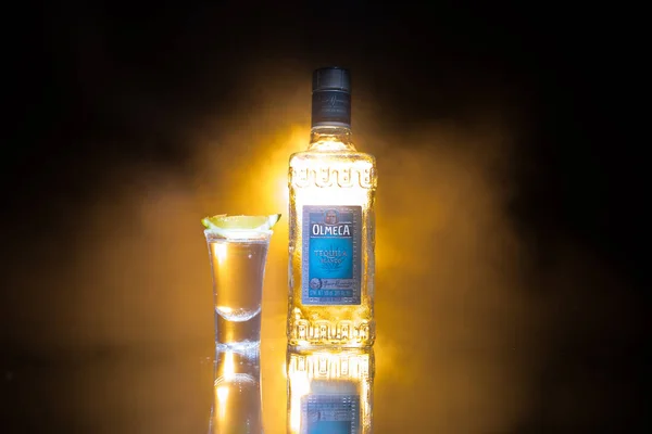 Bakoe, Azerbeidzjan-16 juni. 2019. olmeca Tequila op houten tafel op een donkere getinte mistige achtergrond. Olmeca Tequila is een Tequila geproduceerd in Jalisco, Mexico. — Stockfoto