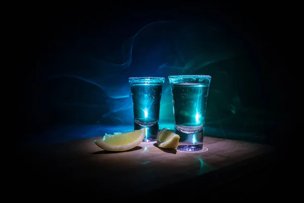 Club drink concept. Tasty alcohol drink cocktail tequila with lime and salt on vibrant dark background or glasses with tequila at a bar — Stock Photo, Image