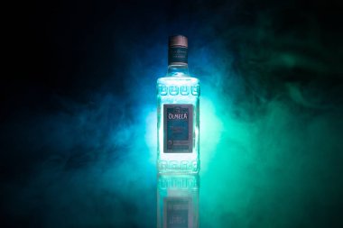 Bakü, Azerbaycan - 16 Haziran. 2019. Koyu tonda sisli arka plan üzerinde ahşap masa üzerinde Olmeca Tekila. Olmeca Tekila Jalisco, Meksika'da üretilen bir tekila.