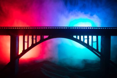 Sanat dekorasyonu. Sisli arka ışık ile geceleri güçlü metalik köprü Siluet. Köprüde duran kişinin silueti.