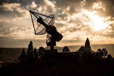Gün batımı gökyüzüne karşı uydu antenleri veya radyo antenleri siluetleri. Uzay gözlemevi.