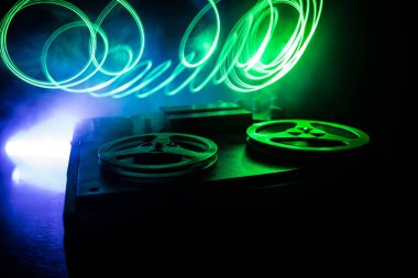 Koyu tonda sisli arka plan üzerinde makara oynatıcı ve kaydedici eski vintage makara. Makaralı Analog Stereo Açık Makara Bant Güverte Kaydedici Çalar.