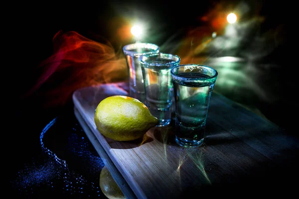 Club drink concept. Tasty alcohol drink cocktail tequila with lime and salt on vibrant dark background or glasses with tequila at a bar — Stock Photo, Image