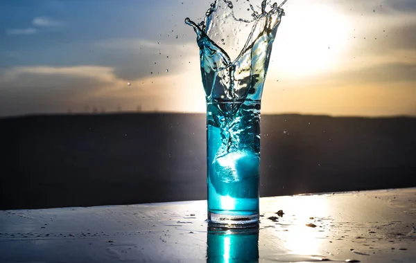 Conceito de bebida refrescante de verão. Óculos de cocktail a salpicar ao pôr-do-sol. Close up copo molhado de bebida fria no terraço . — Fotografia de Stock