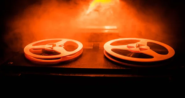 Old vintage reel to reel player and recorder on dark toned foggy background. Analog Stereo Open Reel Tape Deck Recorder Player with Reels.