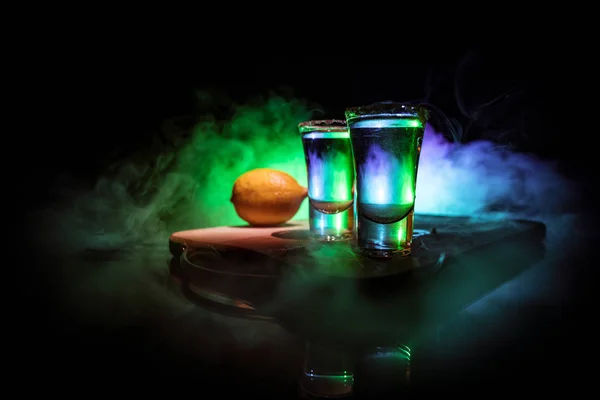 Club Drink Konzept. leckeres Alkoholgetränk Cocktail Tequila mit Limette und Salz auf lebendigem dunklem Hintergrund oder Gläser mit Tequila an der Bar — Stockfoto