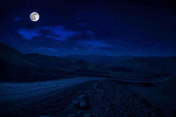 Mountain Road attraverso la foresta in una notte di luna piena. Paesaggio paesaggistico notturno di strada di campagna di notte con grande luna. Tapparella lunga foto — Foto Stock
