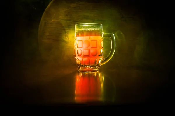 Creative concept. Beer glasses on wooden table at dark toned foggy background. — Stock Photo, Image