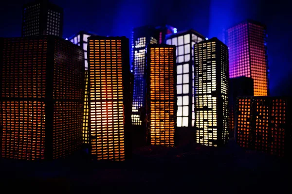 Творческое оформление стола с маленькими городскими зданиями, светящимися ночью. Современные здания города, яркие огни, роскошные путешествия и туристическая концепция — стоковое фото