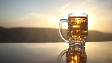 Gün batımında sahilde bira kadehleri. Soğutma yaz içki konsepti. Güneş ışığı Arka Plan, Yumuşak Odak Bokeh ile Draught Bira Bir Bardak Close Up