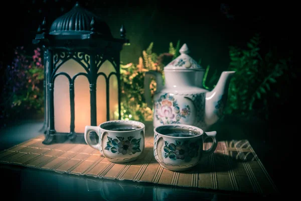 Tea concept. Japanese tea ceremony culture east beverage. Teapot and cups on table with bamboo leaves on sunset — Stock Photo, Image