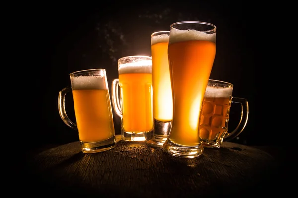 Creative concept. Beer glasses on wooden table at dark toned foggy background. — Stock Photo, Image