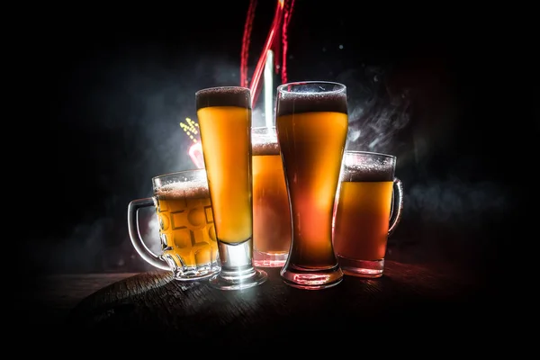 Conceito criativo. copos de cerveja na mesa de madeira no fundo enevoado tonificado escuro . — Fotografia de Stock