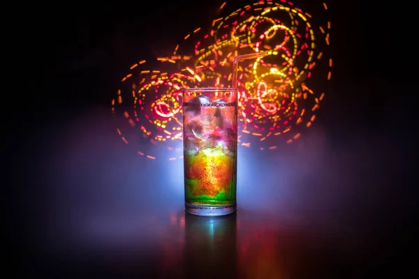 Cocktail glass splashing on dark toned smoky background or colorful cocktail in glass. Party club entertainment. Mixed light. — Stock Photo, Image