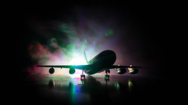 Sanat dekorasyonu. Beyaz yolcu uçağı havaalanı pistinden kalkışa hazır. Gece saatlerinde Uçak Silueti.