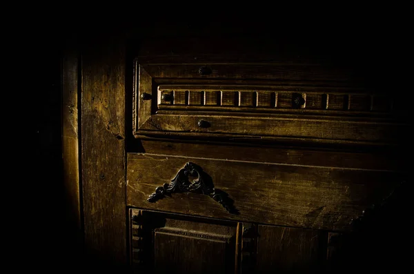 Vista de cerca de la antigua puerta de madera antigua dentro de la habitación oscura. Enfoque selectivo — Foto de Stock