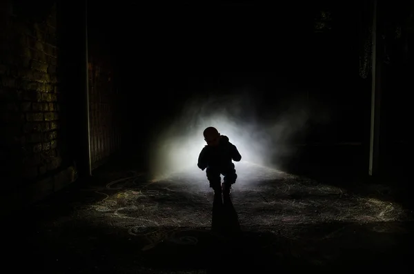 Scena di orrore di un fantasma spaventoso per bambini, silhouette di bambola spaventosa su sfondo scuro nebbioso con luce . — Foto Stock