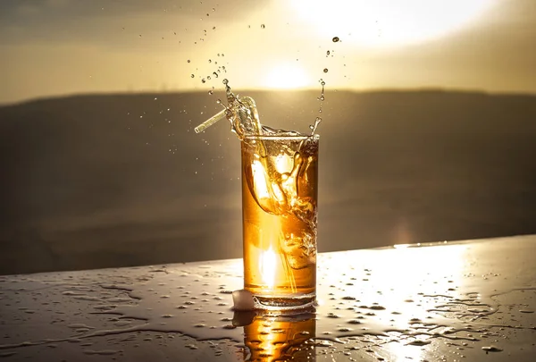 Koeling zomer drank concept. Cocktail glazen spetteren op zonsondergang. Close-up nat glas koud drankje op het terras. — Stockfoto