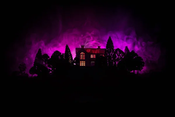 Gammalt hus med ett spöke i skogen på natten eller övergivna skräck spökhuset i dimma. Gamla mystiska byggnaden i döda träd skogen. Träd på natten med månen. Surrealistiska lampor. — Stockfoto