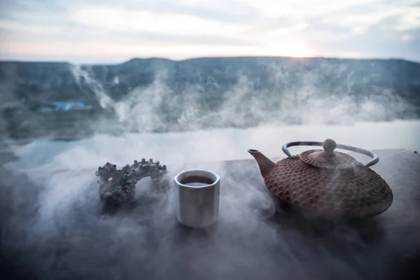 Koncept čaje. Japonská čajová ceremonie, východní nápoj. Čajník a šálky na stole s bambusovými listy při západu slunce — Stock fotografie