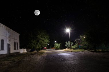 Gece oldukça köy üzerinde dolunay. Işıklar ile eski şehir caddesi güzel gece manzara. Rusya