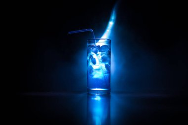 Kokteyl cam koyu tonda dumanlı arka plan veya cam renkli kokteyl sıçrayan. Parti kulübü eğlencesi. Karışık ışık.