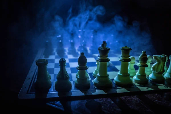 Juego de mesa de ajedrez concepto de ideas de negocio y competencia. Figuras de ajedrez sobre un fondo oscuro con humo y niebla . —  Fotos de Stock