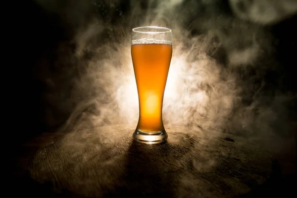 Kreativt koncept. Ölglas på träbord på mörkt tonas dimmigt bakgrund. — Stockfoto