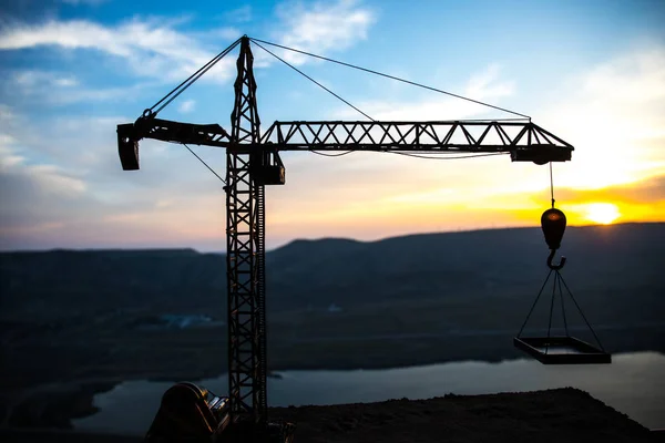 Resumo Fundo industrial com silhueta de guindaste de construção sobre incrível céu pôr do sol. Torre guindaste contra o céu da noite. Linha do horizonte industrial — Fotografia de Stock