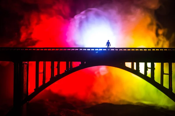 Художественное оформление. Силуэт мощного металлического моста ночью с туманной подсветкой. Силуэт человека, стоящего на мосту . — стоковое фото
