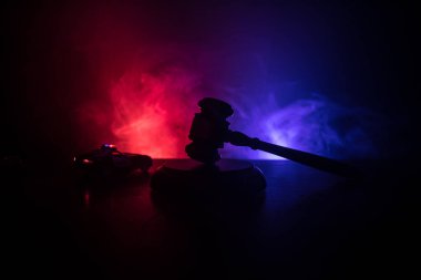 Yasal hukuk kavramı. Yanıp sönen kırmızı ve mavi polis ışıkları sisli arka plan, arka üzerinde adalet heykeli ile kelepçe silüeti. Seçici odak