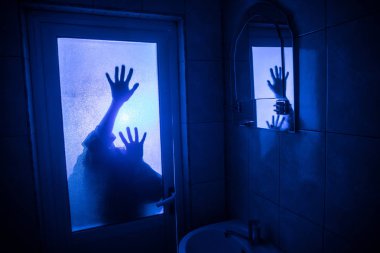 Horror silhouette of woman in window. Scary halloween concept Blurred silhouette of witch in bathroom. Selective focus clipart