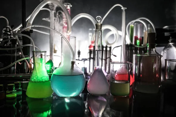 Pharmacy and chemistry theme. Test glass flask with solution in research laboratory. Science and medical background. Laboratory test tubes on dark toned background — Stock Photo, Image