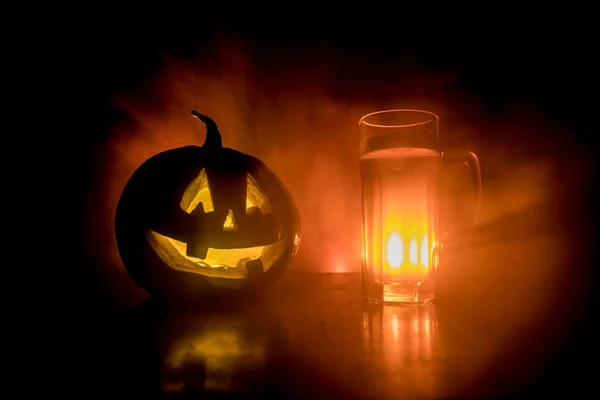 Verre de bière froide et légère avec citrouille sur fond de bois pour Halloween. Verre de bière fraîche et de citrouille sur fond brumeux foncé — Photo