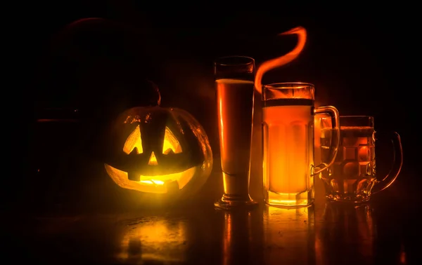 Bicchiere di birra leggera fredda con zucca su uno sfondo di legno per Halloween. Bicchiere di birra fresca e zucca su uno sfondo scuro tonico nebbioso — Foto Stock