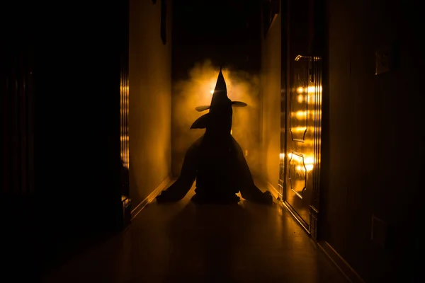 Kuslig silhuett i den mörka övergivna byggnaden. Skräck Halloween koncept. Mörk korridor med siluett av skräck person som står i centrum. Tonas ljus och dimma på bakgrunden. Selektivt fokus — Stockfoto