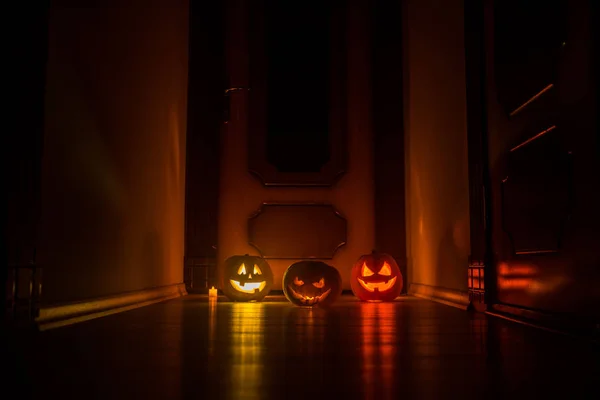 Halloween citrouille tête Jack o lanterne avec des bougies incandescentes sur fond. Citrouilles sur le sol en bois — Photo