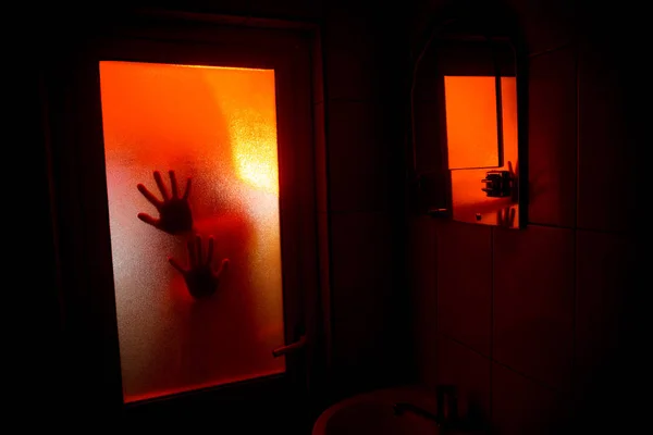 Horror silhouette of woman in window. Scary halloween concept Blurred silhouette of witch in bathroom. Selective focus