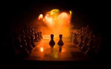 İş fikirleri ve rekabet Satranç tahtası oyun kavramı. Duman ve sis ile karanlık bir arka plan üzerinde Satranç rakamlar.