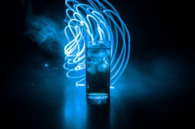 Kokteyl cam koyu tonda dumanlı arka plan veya cam renkli kokteyl sıçrayan. Parti kulübü eğlencesi. Karışık ışık.