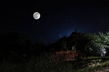 Gece oldukça köy üzerinde dolunay. Işıklar ile eski şehir caddesi güzel gece manzara. Rusya