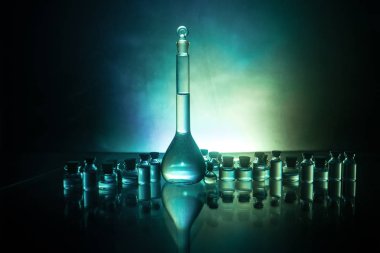 Eczacılık ve kimya teması. Araştırma laboratuvarında solüsyon lu cam şişesi test edin. Bilim ve tıbbi geçmiş. Koyu tonlu arka plan üzerinde laboratuvar test tüpleri