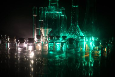 Eczacılık ve kimya teması. Araştırma laboratuvarında solüsyon lu cam şişesi test edin. Bilim ve tıbbi geçmiş. Koyu tonlu arka plan üzerinde laboratuvar test tüpleri
