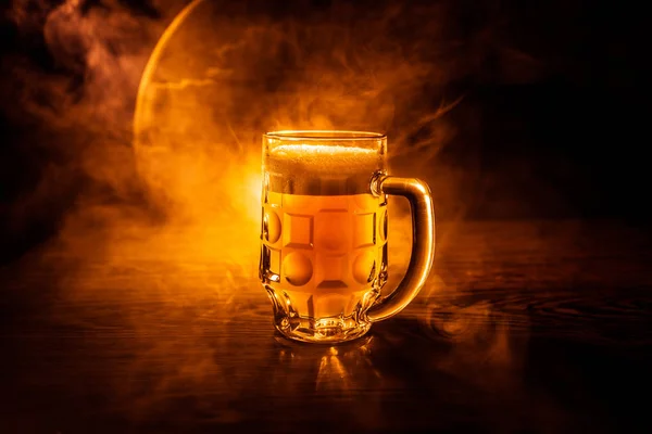 Creative concept. Beer glasses on wooden table at dark toned foggy background. — Stock Photo, Image