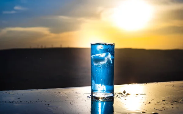 Conceito de bebida refrescante de verão. Óculos de cocktail a salpicar ao pôr-do-sol. Close up copo molhado de bebida fria no terraço . — Fotografia de Stock