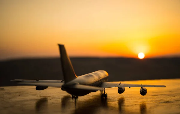 Artwork decoration. White passenger plane ready to taking off from airport runway. Silhouette of Aircraft during sunset time.