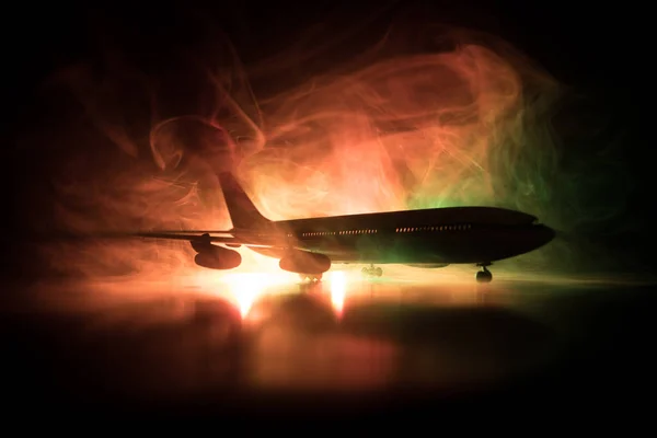 Artwork decoration. White passenger plane ready to taking off from airport runway. Silhouette of Aircraft during night time.