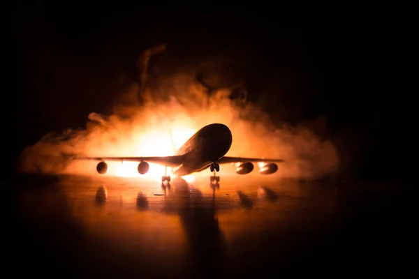 Artwork decoration. White passenger plane ready to taking off from airport runway. Silhouette of Aircraft during night time.