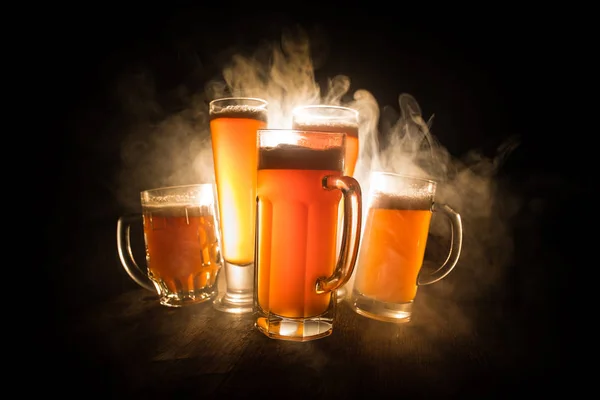 Creatief concept. Bier glazen op houten tafel op donkere toned mistige achtergrond. — Stockfoto